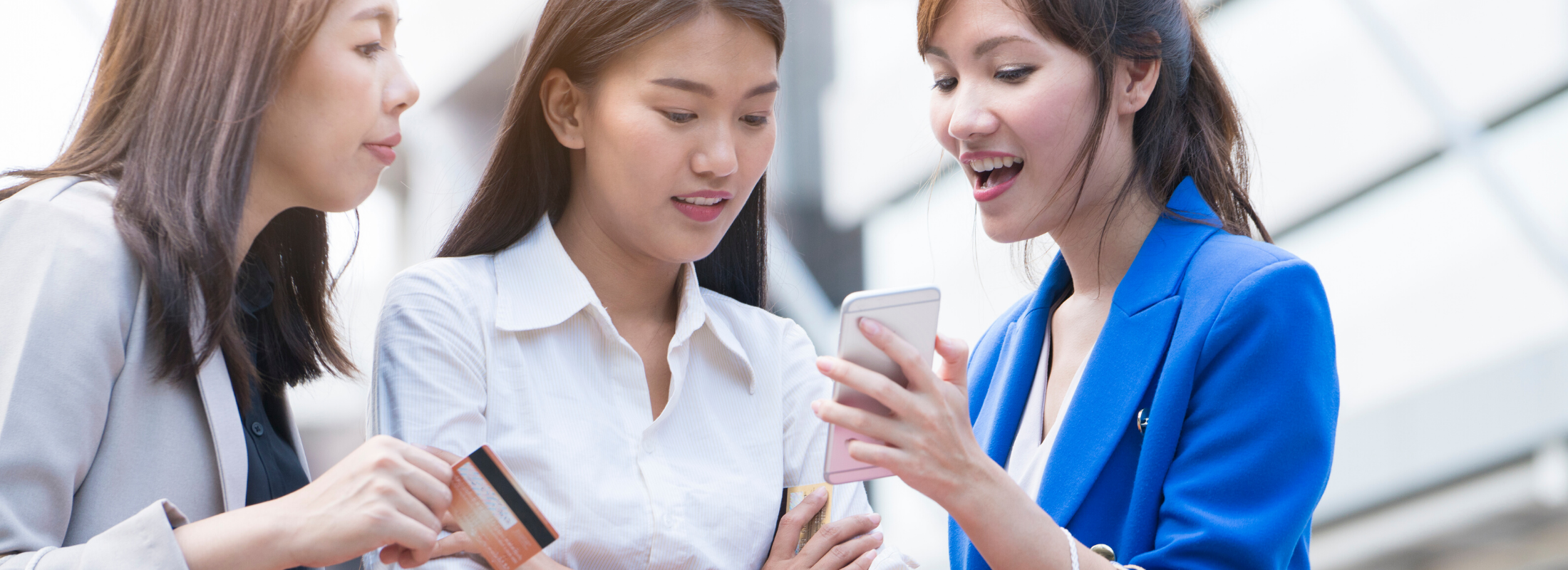 Three girls are looking at smartphone for online shopping